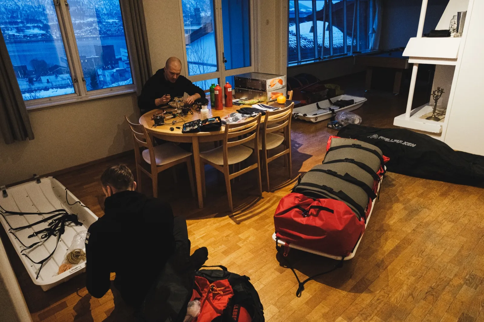 Retkikunnan varusteita ja ahkiot pakattavina ennen lähtöä